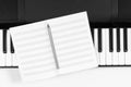 Music learning background. Piano keyboard and open blank sheet music notebook. Top view Royalty Free Stock Photo