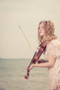 Woman playing violin on violin near beach Royalty Free Stock Photo