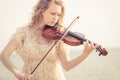 Woman playing violin on violin near beach Royalty Free Stock Photo