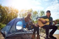 Music is only love looking for words. a young man playing his girlfriend a song on his guitar while out camping. Royalty Free Stock Photo