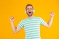 Music makes me happy. Happy man listen to music yellow background. Handsome guy enjoy melody playing in headphones