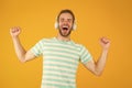 Music makes me happy. Happy man listen to music yellow background. Handsome guy enjoy melody playing in headphones