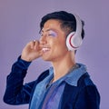 Music, makeup and cyberpunk with an asian man model in studio on a purple background for lgbt freedom. Future, happy and