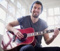 Music is more than just a hobby for me. Portrait of a handsome young man playing a guitar at home. Royalty Free Stock Photo