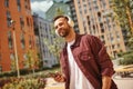 Music in my heart. Cheerful young man with stubble in headphones listening to the music and holding mobile phone while Royalty Free Stock Photo