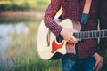 Music in nature, Man playing an acoustic guitar in meadow