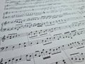 Music notes background. Musical concept macro view of white score sheet music Royalty Free Stock Photo