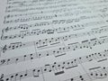 Music notes background. Musical concept macro view of white score sheet music Royalty Free Stock Photo