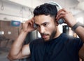 Music on, now lets begin. Shot of a sporty young man listening to music while exercising in a gym. Royalty Free Stock Photo