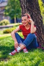 Music passion- Happy woman listens to music via headphones and smartphone in the park