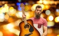 Male musician with guitar over night city lights Royalty Free Stock Photo