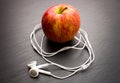 Music playing apple in which earphones are connected.