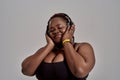 Music. Plump, plus size african american woman in sportswear and headphones listening to music, standing in studio over Royalty Free Stock Photo