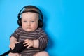 Music or podcast background with baby boy with headphones and microphone on blue table, flat lay. Top view, flat lay Royalty Free Stock Photo