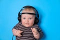 Music or podcast background with baby boy with headphones and microphone on blue table, flat lay. Top view, flat lay Royalty Free Stock Photo