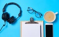 Music or podcast background with headphones, microphone, coffee and blank on blue table, flat lay. Top view, flat lay Royalty Free Stock Photo