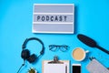 Music or podcast background with headphones, microphone, coffee and blank on blue table, flat lay. Top view, flat lay Royalty Free Stock Photo