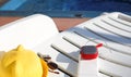 Music portable speaker is charged from the power bank via usb on a deck chair near the pool with beach accessories. Royalty Free Stock Photo