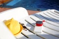 Music portable speaker is charged from the power bank via usb on a deck chair near the pool with beach accessories. Royalty Free Stock Photo