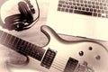 Music production. Writing music with electric guitar, laptop computer and headphones