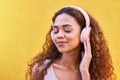 Music, quiet and peaceful with a black woman listening to the radio outdoor on a yellow wall background. Headphones Royalty Free Stock Photo