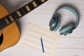 Music recording scene with guitar, empty music sheet, pencil and headphones Royalty Free Stock Photo