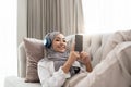 Music For Relax. Calm asian Girl In Hijab And Wireless Headphones Listening Favorite Songs At Home, Resting On Royalty Free Stock Photo