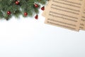 Music sheets near fir tree branches with Christmas balls and space for text on white background, flat lay Royalty Free Stock Photo