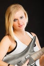 Blonde woman holding electric guitar, black background