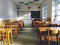 Music solfeggio empty class at school. The sun's rays fall on the floor through the window. Wooden student tables