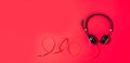 Music and sound concept. Style black headphones on red background. Top view. Copy space. Urban summer time. Banner