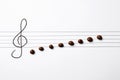 Music staff with treble clef and chocolate candies as notes on white paper, flat lay. Creativity concept Royalty Free Stock Photo