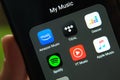 Music streaming apps on the screen of the smartphone hold in hand. Concept for competition. Close up photo Royalty Free Stock Photo