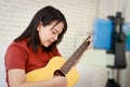 Music teacher plays guitar online live via smartphone.