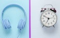 Music time concept. Retro alarm clock and headphones on creative background. Top view. Royalty Free Stock Photo