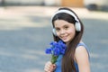 Music to your ears. Happy baby with flowers listen to music. Little girl wear headphones playing music. Summer vacation Royalty Free Stock Photo