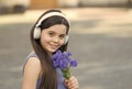 Music to your ears. Happy baby with flowers listen to music. Little girl wear headphones playing music. Summer vacation Royalty Free Stock Photo