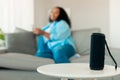 Musical Column Standing On Table While Lady Listening Music Indoors