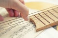 Musical conceptual composition fingers from the fingers smash the strings of the guitar against the background of musical paper Royalty Free Stock Photo