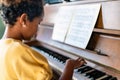 Musical education. Happy black girl playing the piano