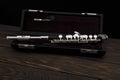 Musical instrument, flute with a case on a wooden surface on a black background Royalty Free Stock Photo