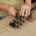 Guitar repair and service - Worker fix a new strings black acoustic guitar Royalty Free Stock Photo