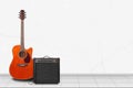 Home interior - Orange acoustic guitar, amplifier of white wall Royalty Free Stock Photo