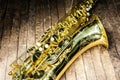 part of the case tube with pockets and bells of a yellow saxophone on an old wooden surface Royalty Free Stock Photo