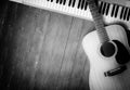 Musical instrument - MIDI keyboard and acoustic guitar wood background monochrome Royalty Free Stock Photo