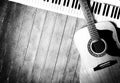 Musical instrument - MIDI keyboard and vintage acoustic guitar wood background monochrome Royalty Free Stock Photo