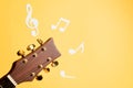 Musical notes and guitar fretboard close up, flat lay on yellow background. Music backdrop