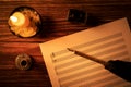 Musical notes sheet with vintage feather quill pen in candlelight Royalty Free Stock Photo