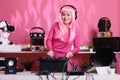 Musical performer with pink hair playing electronic song at professional turntables Royalty Free Stock Photo