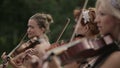 Musical quartet. Three violinists and cellist playing music. Close up.